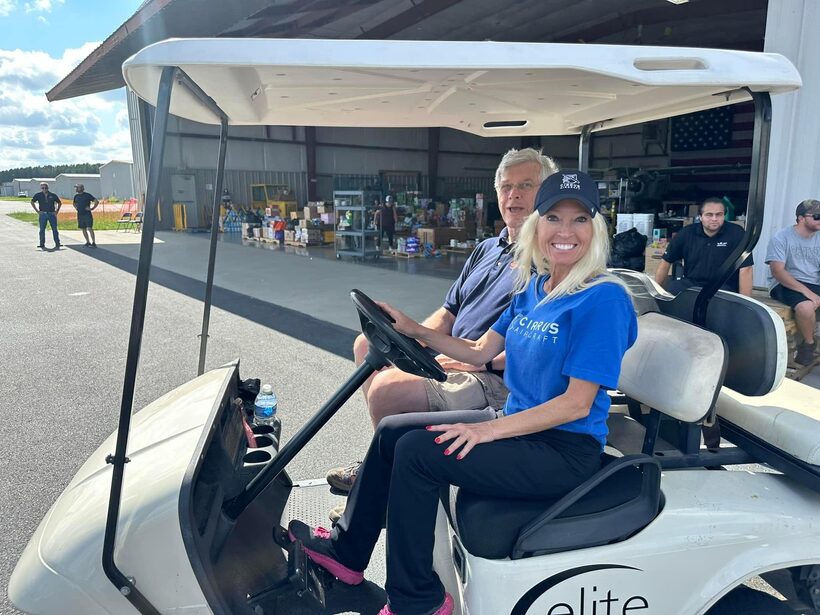 Elite Aircraft Services staff on a golf cart in front of an open hangar